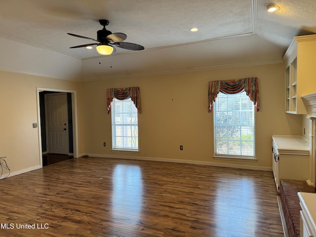 spare room featuring baseboards, ornamental molding, a raised ceiling, and dark wood-style flooring