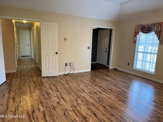 spare room featuring baseboards, ornamental molding, and wood finished floors