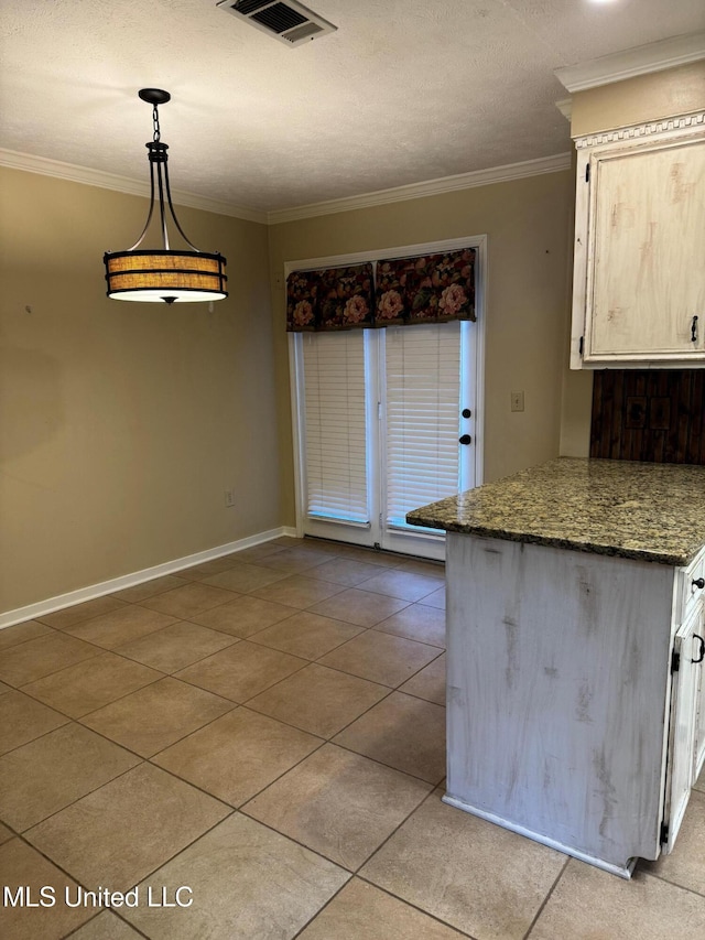 kitchen featuring light tile patterned floors, baseboards, visible vents, and ornamental molding