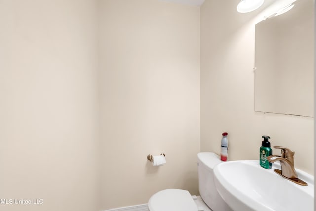 half bathroom featuring toilet and a sink