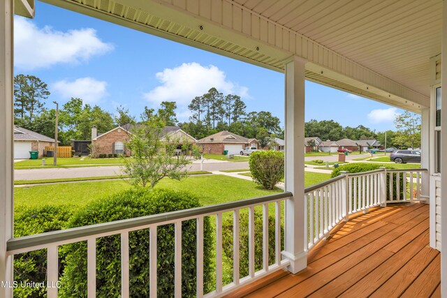 wooden deck featuring a porch, a yard, and a residential view