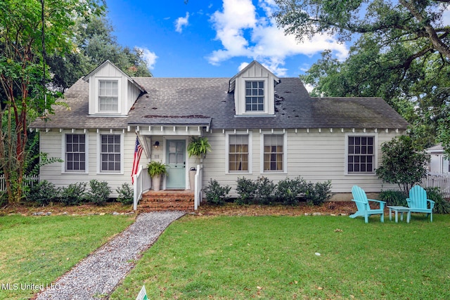 cape cod house with a front yard