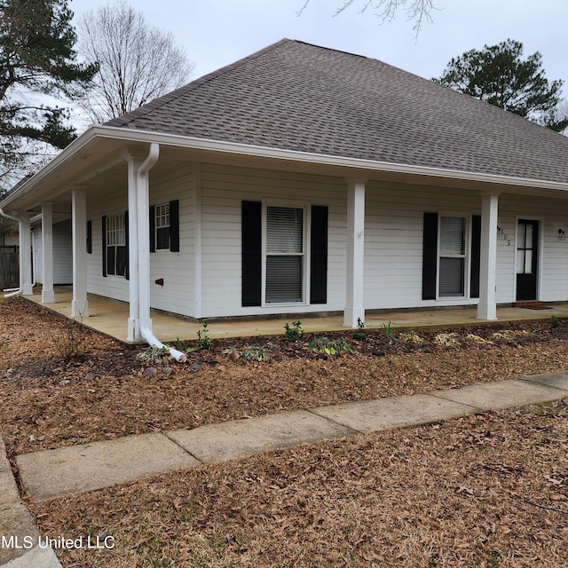 view of front of home featuring covered porch and a shingled roof