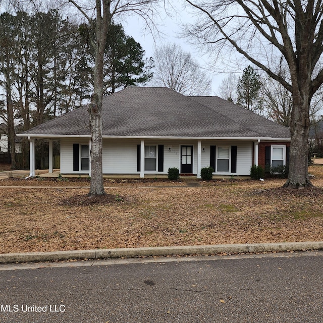 ranch-style home with roof with shingles and covered porch