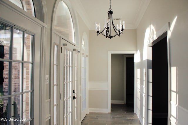 corridor featuring a chandelier, french doors, dark hardwood / wood-style floors, and ornamental molding