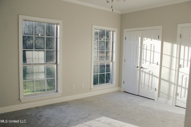 foyer with light colored carpet, ceiling fan, and crown molding