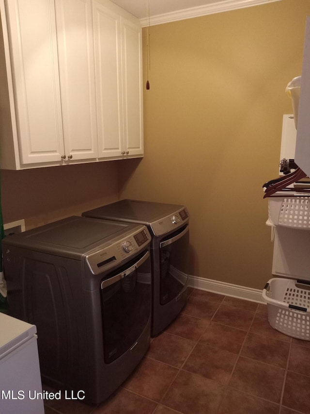496 Cleveland Crossing Rd, Cleveland, MS 38732 - washroom featuring washing machine and clothes dryer, cabinet space, baseboards, ornamental molding, and dark tile patterned flooring