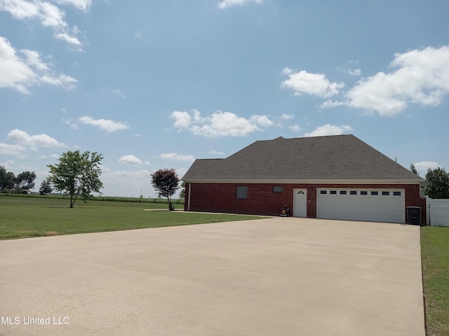 496 Cleveland Crossing Rd, Cleveland, MS 38732 - view of property exterior featuring a lawn, driveway, brick siding, an attached garage, and roof with shingles
