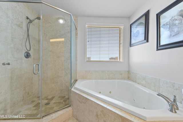 bathroom featuring plenty of natural light, a tub with jets, and a shower stall