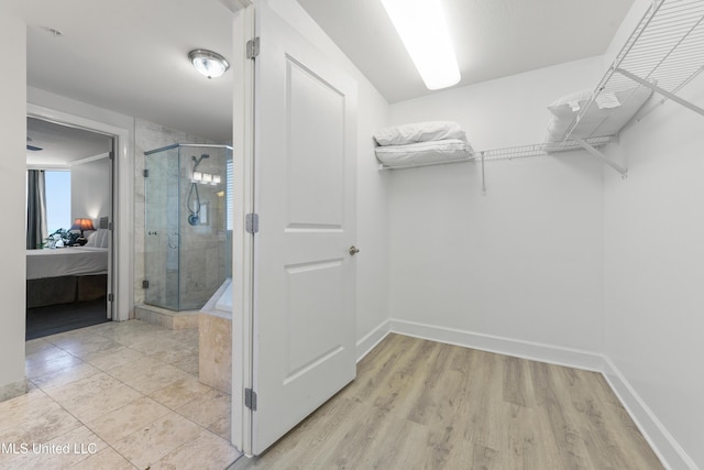 walk in closet with light wood-style flooring