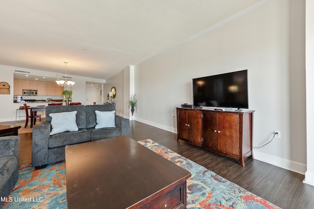 living area with dark wood finished floors, crown molding, a notable chandelier, and baseboards