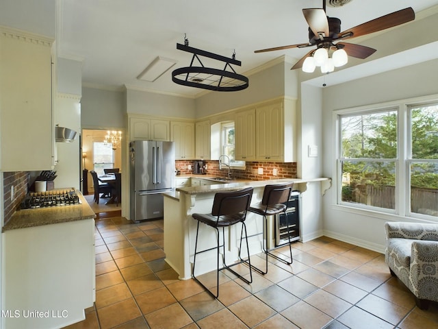 kitchen with extractor fan, kitchen peninsula, decorative backsplash, sink, and stainless steel appliances