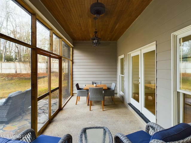 sunroom / solarium featuring a healthy amount of sunlight and wooden ceiling