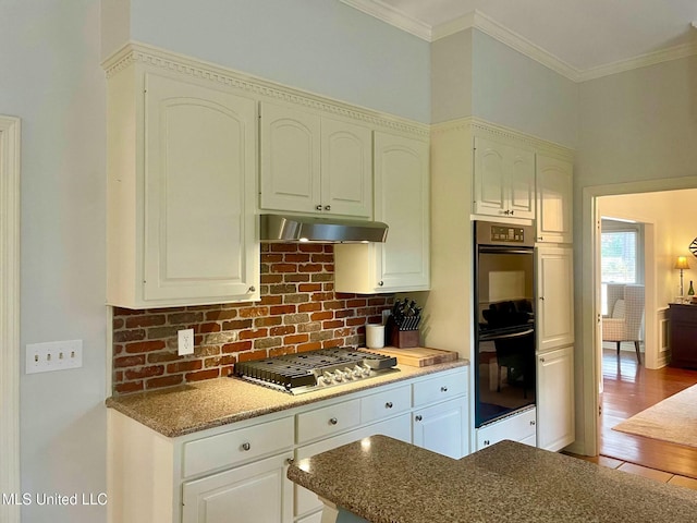 kitchen featuring tasteful backsplash, stainless steel gas stovetop, crown molding, white cabinets, and double oven