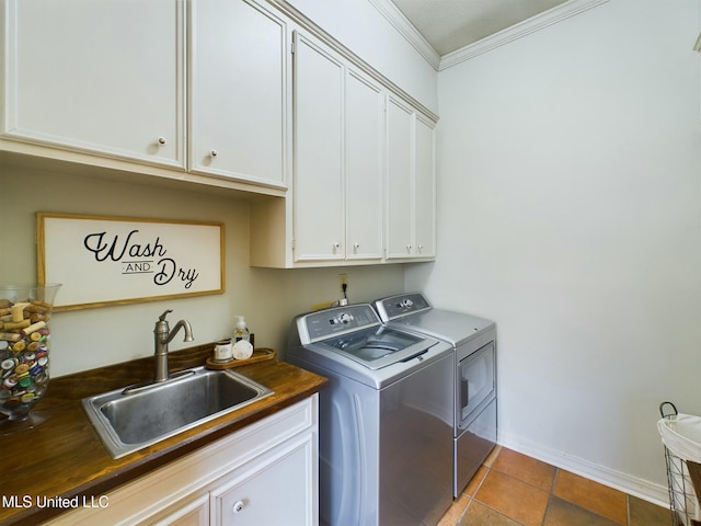 laundry room featuring washer and clothes dryer, tile patterned flooring, cabinets, sink, and crown molding