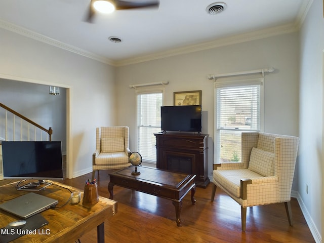 living room with a wealth of natural light, crown molding, and hardwood / wood-style floors