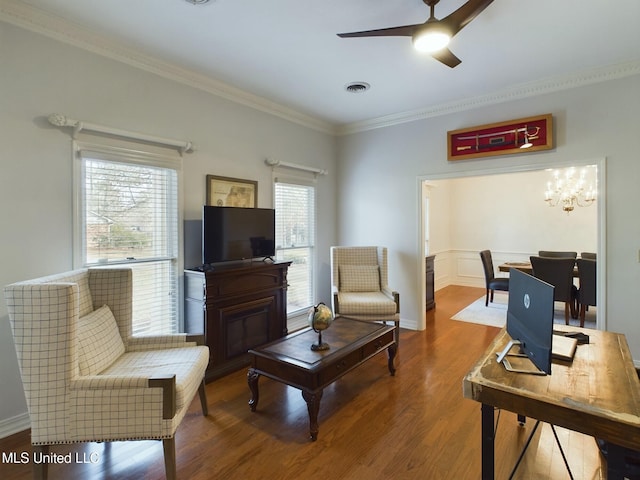 living room featuring ceiling fan with notable chandelier, wood-type flooring, and ornamental molding