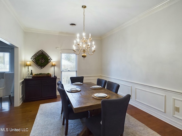 dining space featuring dark hardwood / wood-style floors, ornamental molding, and a notable chandelier