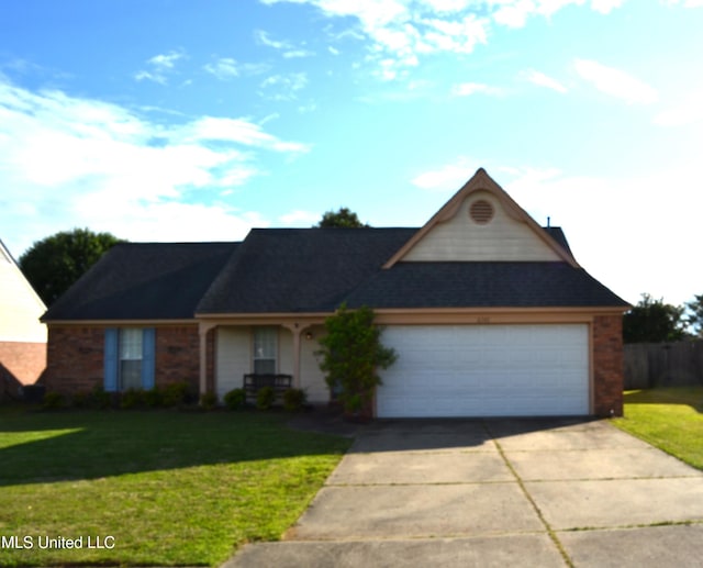 view of front of property featuring a front yard, driveway, a garage, and brick siding
