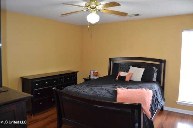 bedroom featuring wood finished floors, a ceiling fan, and baseboards