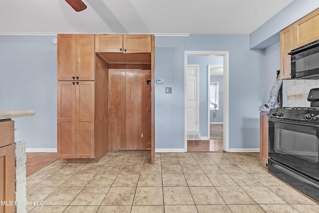 6830 Embassy Cir, Horn Lake, MS 38637 - kitchen with black appliances, baseboards, light brown cabinetry, and a ceiling fan