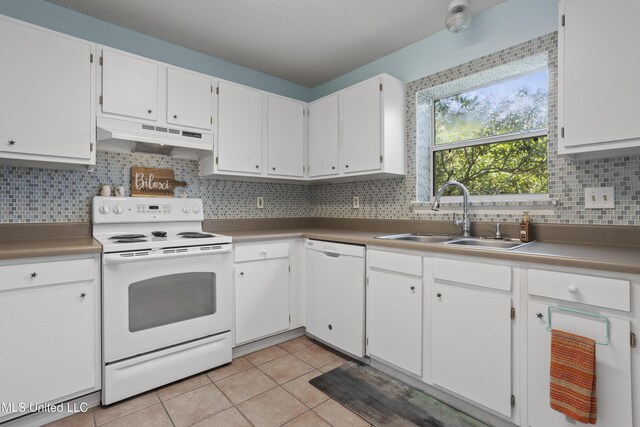 172 Briarfield Ave, Biloxi, MS 39531 - kitchen featuring white appliances, under cabinet range hood, light tile patterned floors, tasteful backsplash, and white cabinets