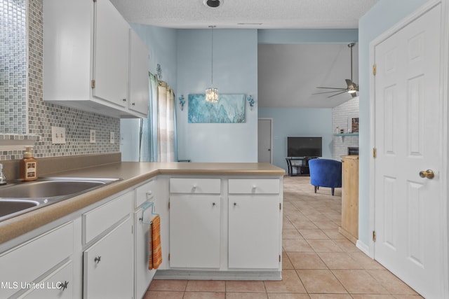 172 Briarfield Ave, Biloxi, MS 39531 - kitchen featuring ceiling fan, light tile patterned flooring, white cabinets, a fireplace, and a textured ceiling