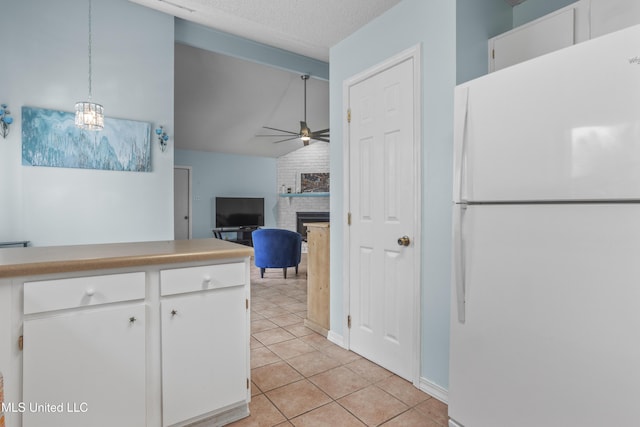 172 Briarfield Ave, Biloxi, MS 39531 - kitchen featuring freestanding refrigerator, light tile patterned flooring, ceiling fan, white cabinetry, and a brick fireplace