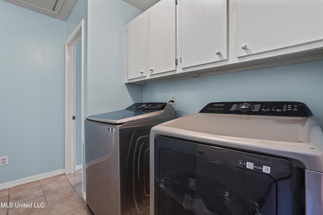 172 Briarfield Ave, Biloxi, MS 39531 - laundry room featuring washing machine and clothes dryer, cabinet space, and light tile patterned floors