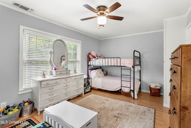 bedroom featuring ornamental molding, light hardwood / wood-style flooring, and ceiling fan