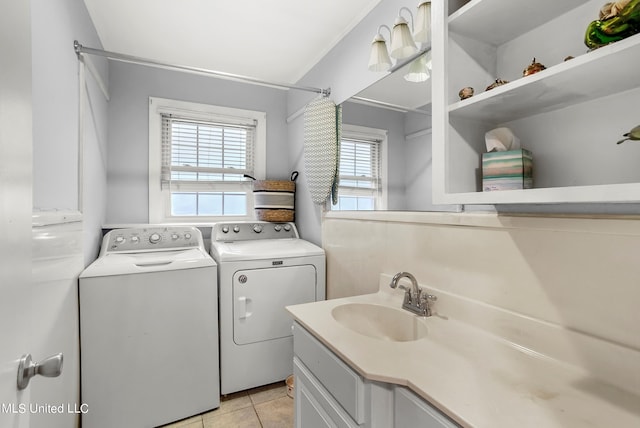 laundry room featuring sink, light tile patterned flooring, and washing machine and dryer