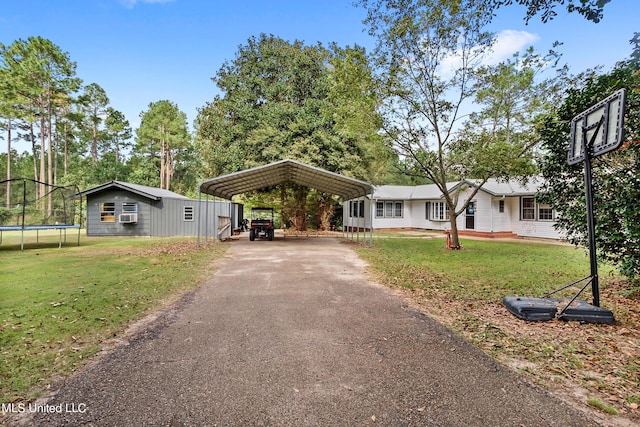 view of front of home with a shed, a front lawn, and a carport