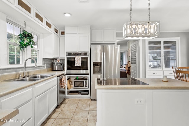 kitchen featuring tasteful backsplash, sink, light tile patterned flooring, white cabinetry, and stainless steel appliances