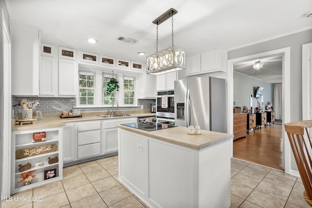 kitchen featuring hanging light fixtures, a kitchen island, appliances with stainless steel finishes, white cabinetry, and sink