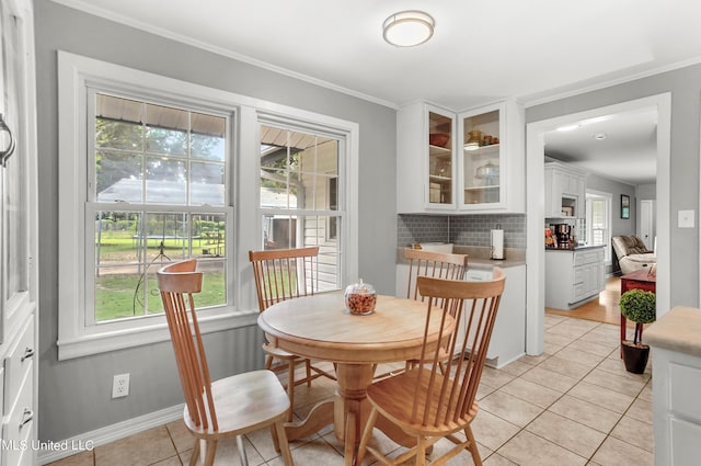 tiled dining area featuring crown molding