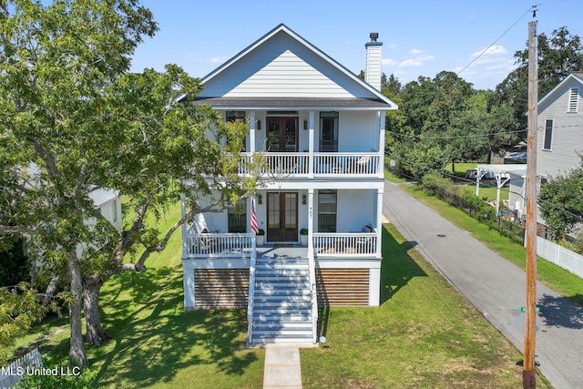 raised beach house with a porch and a front yard