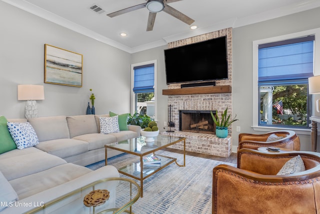 living room featuring a brick fireplace, ceiling fan, ornamental molding, and hardwood / wood-style flooring