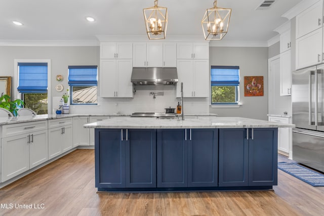 kitchen with light stone countertops, stainless steel built in refrigerator, and a notable chandelier