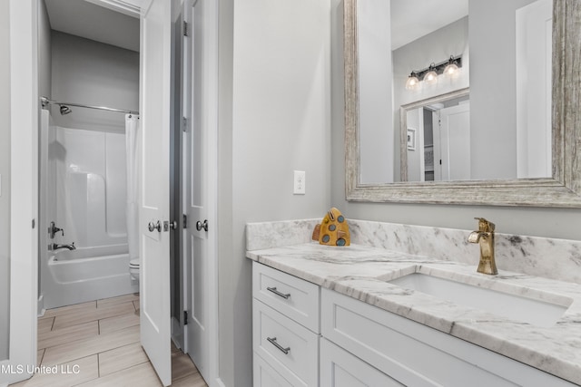 full bathroom with vanity, shower / tub combo, and toilet