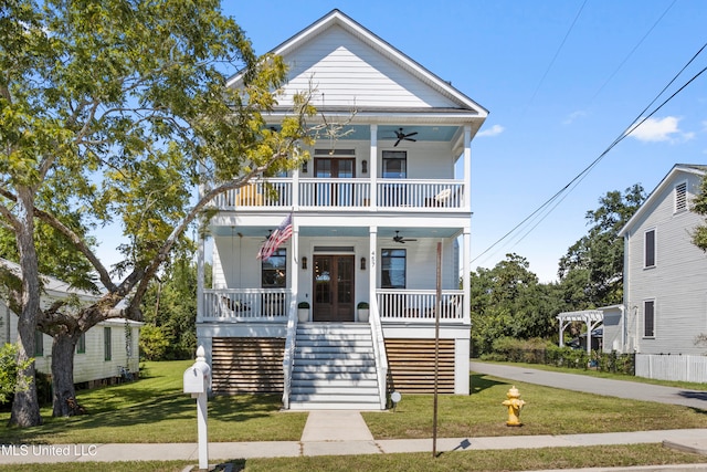 view of front of house featuring covered porch, a balcony, and a front lawn