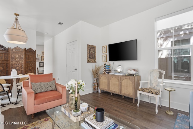 living area featuring wood finished floors, visible vents, and baseboards