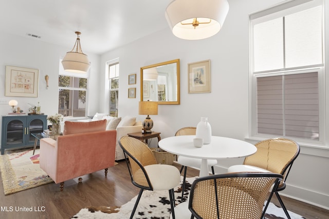 dining area featuring dark wood-style floors, visible vents, and baseboards