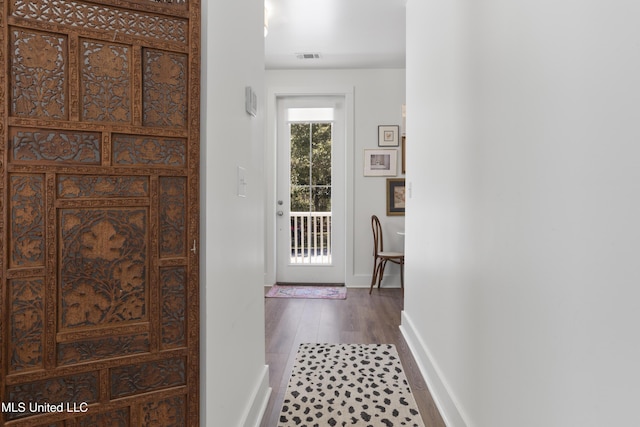 doorway featuring dark wood finished floors, visible vents, and baseboards