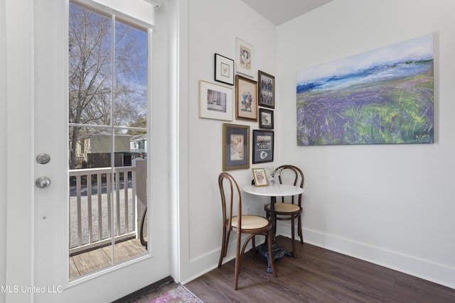 doorway with wood finished floors and baseboards