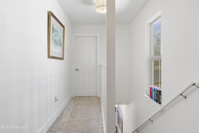 corridor with carpet floors and baseboards