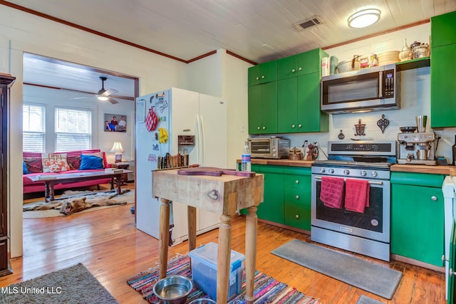 kitchen with crown molding, light hardwood / wood-style floors, green cabinetry, and appliances with stainless steel finishes