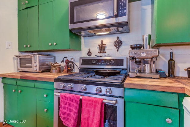 kitchen with butcher block countertops, stainless steel appliances, and green cabinetry