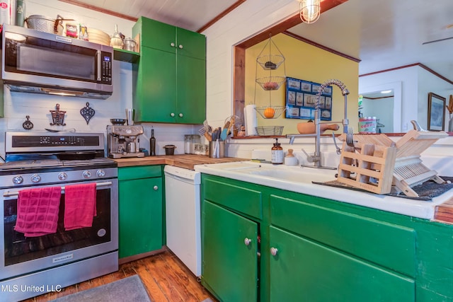 kitchen featuring ornamental molding, appliances with stainless steel finishes, light hardwood / wood-style floors, and green cabinets