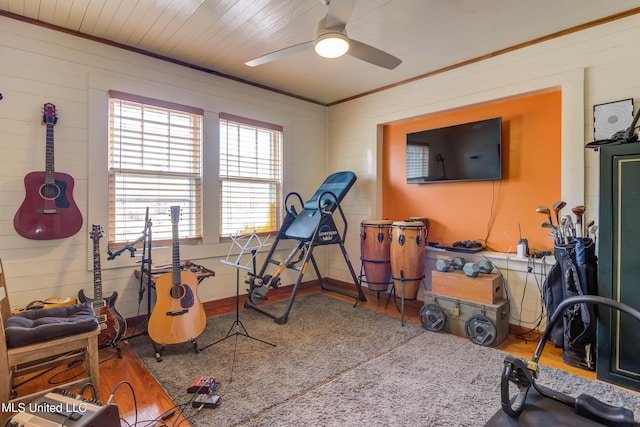 workout room featuring hardwood / wood-style flooring, ornamental molding, and ceiling fan