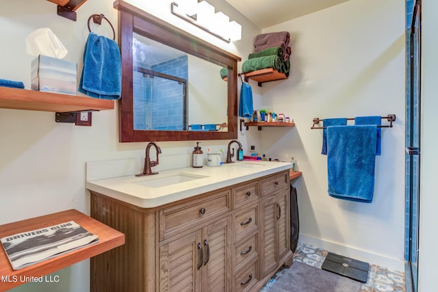 bathroom with a shower with door, vanity, and tile patterned floors